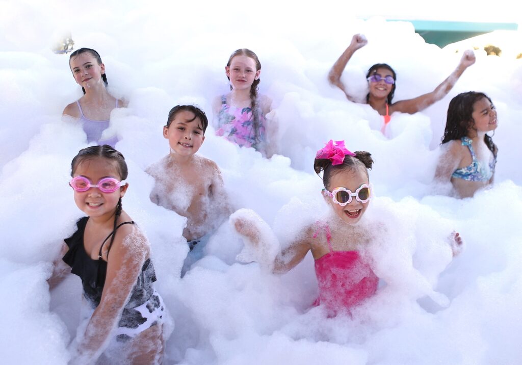 Kids laughing and playing in a thrilling foam party in Evans City, PA, surrounded by fluffy white foam for an unforgettable celebration.