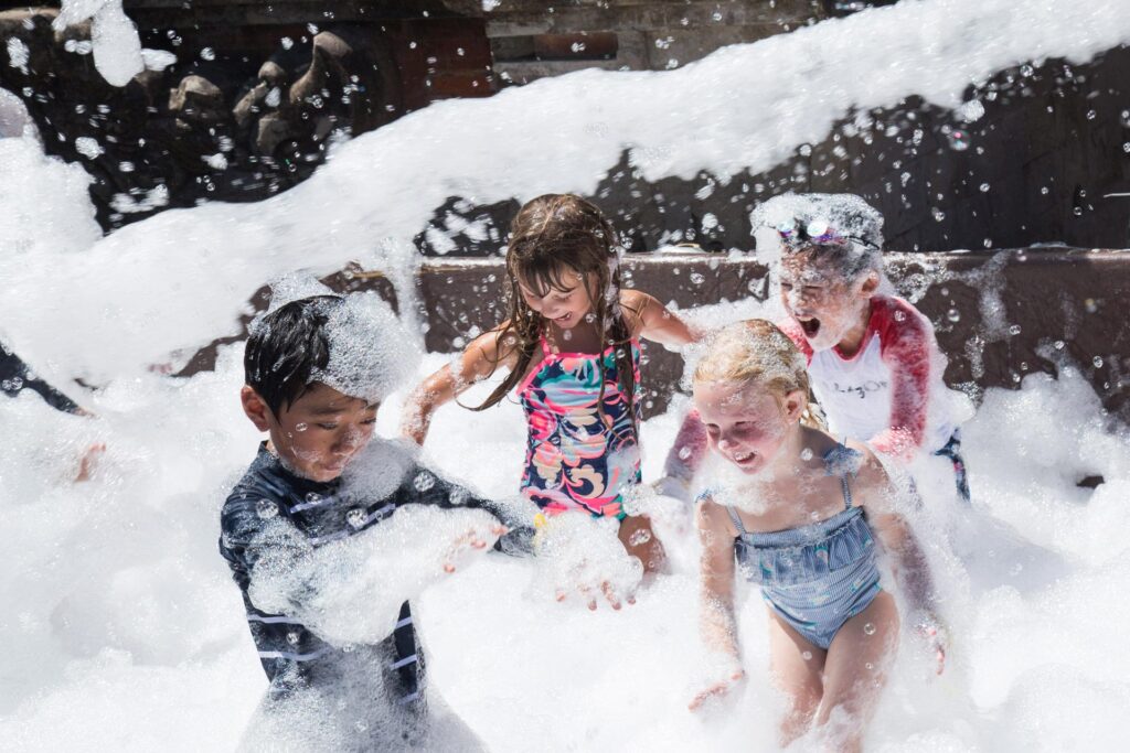 Kids laughing and playing in a bubbly wonderland at Foam Parties in Evans City, PA, enjoying a fun, safe, and unforgettable experience.