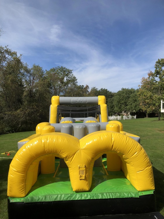 Yellow and green inflatable bounce house rental set up outdoors in pittsburgh, pa