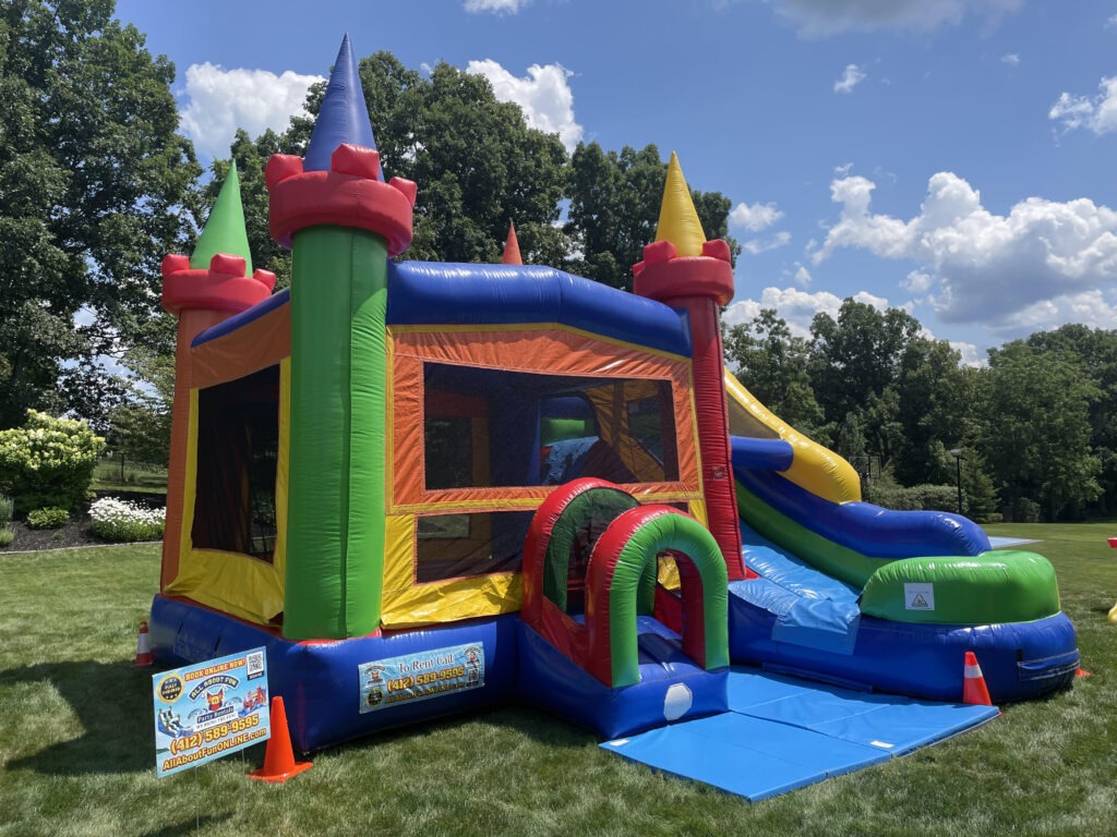 Colorful bounce house and slide rental set up on grass