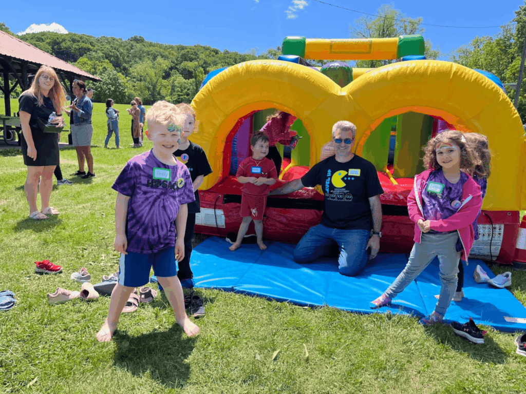 Children enjoying a colorful bounce house rental at an outdoor party in pittsburgh, pa