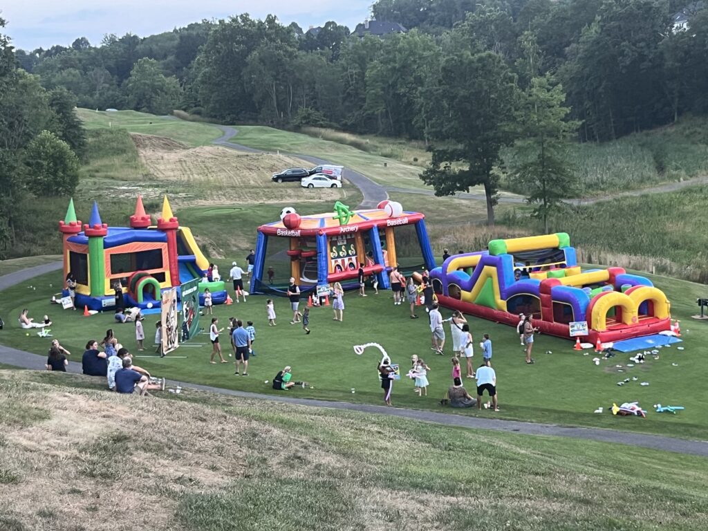 Community event with inflatable bounce houses and obstacle courses
