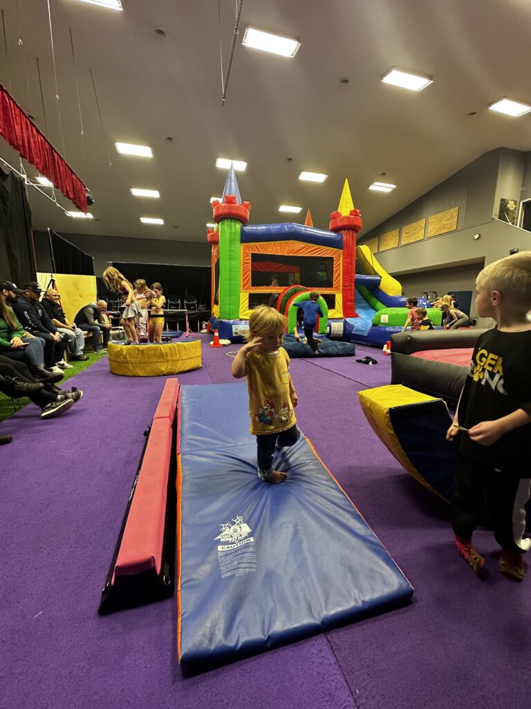 Indoor bounce house rental with kids playing at community event