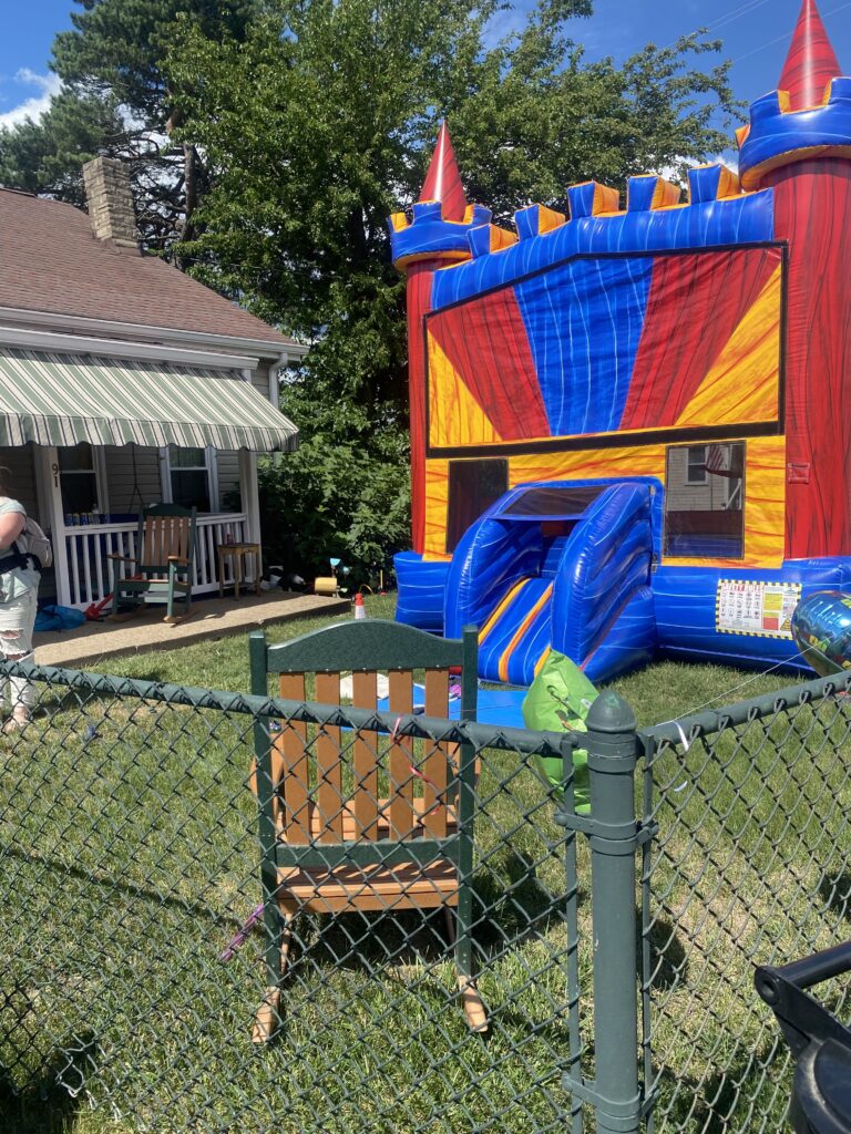 Colorful inflatable bounce house with slide set up in backyard
